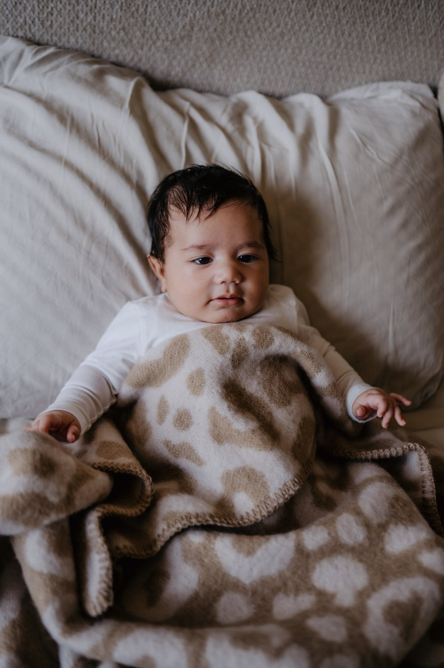 Baby onder wollen wiegdeken van pure baby love